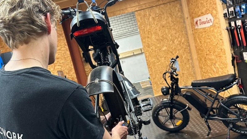 Monteur monteert achterwiel van elektrische fatbike – onderdeel van complete onderhoudsbeurt.