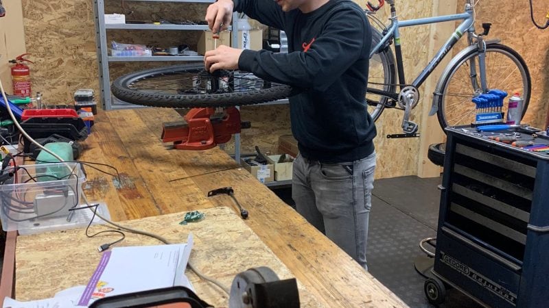 Precisiewerk aan e-bike wiel op de werkbank – specialist in elektrische fietsreparatie en onderhoud.
