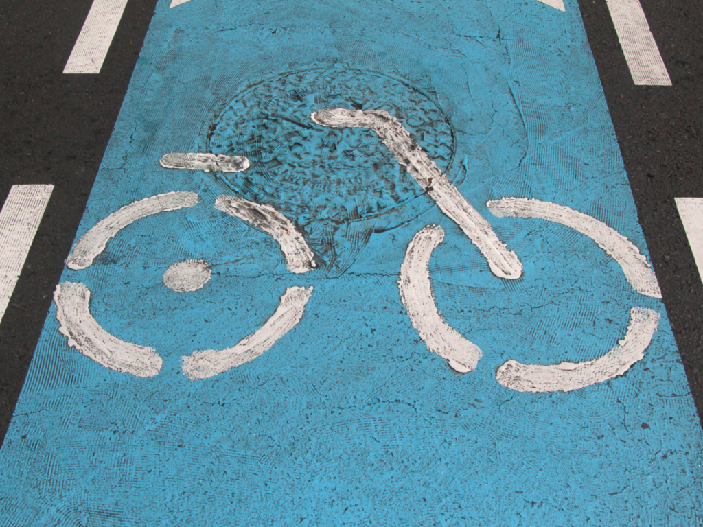 Fietspad markering met symbool voor elektrische fiets en aandacht voor verkeersregels en veiligheid