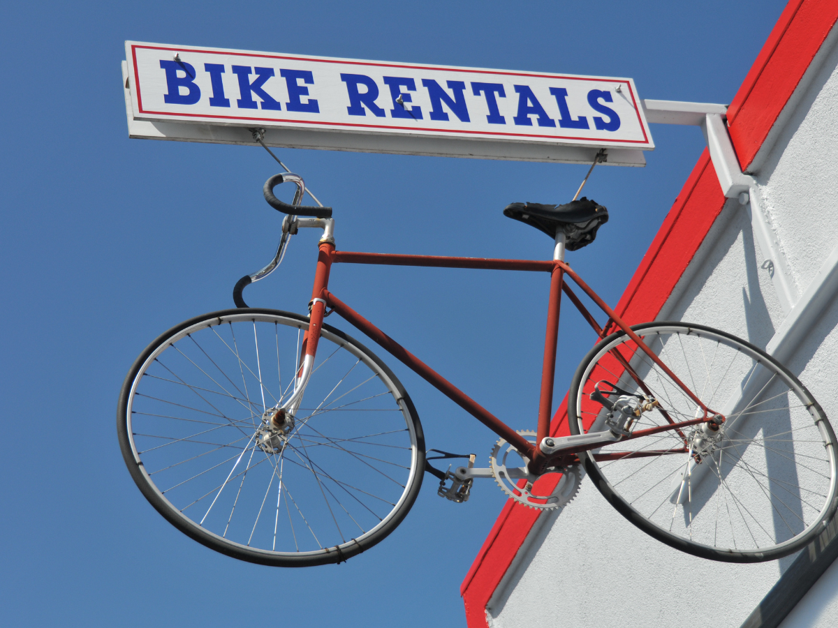 Fietsverhuur bord met fiets als symbool voor elektrische fiets huren en testen