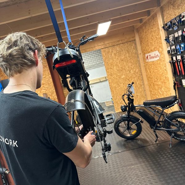 Monteur monteert achterwiel van elektrische fatbike – onderdeel van complete onderhoudsbeurt.